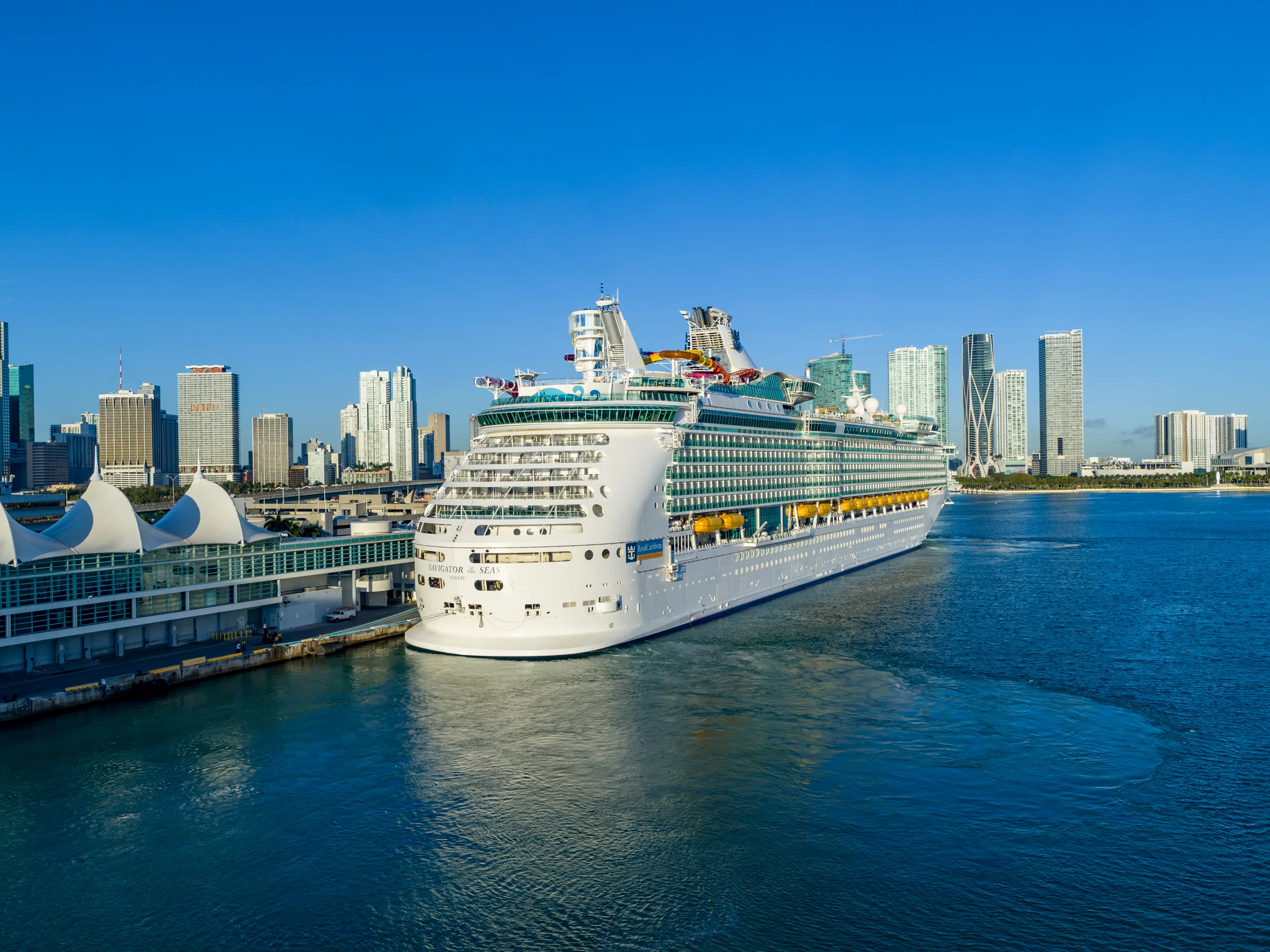 Cruise ship docked in front of a city skyline